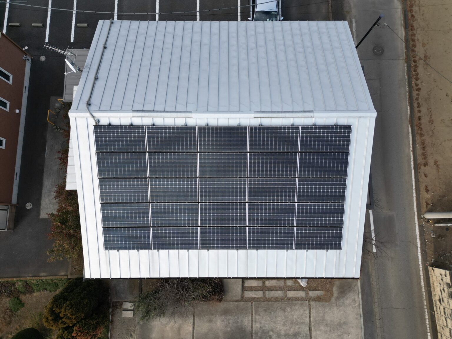ドローンによる屋根面の点検：住宅の上空を飛行するドローンとタブレット操作